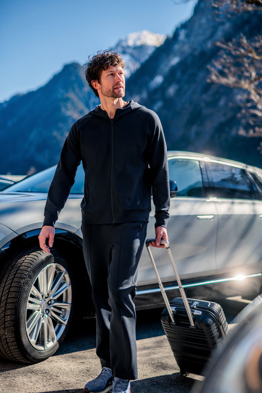 Mann iført mørk navy Travel Hoodie og travel pants fra Pysjkompaniet i minimalistisk premium travel wear-design.