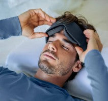 Mann som sover med svart blackout temperaturbalanserende sovemaske