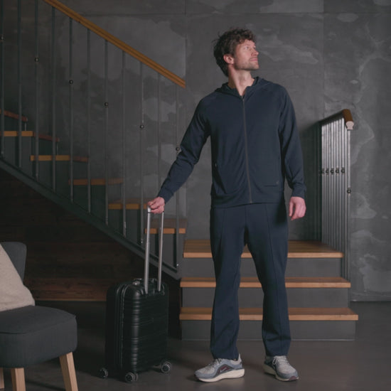 Mann iført mørk navy Travel Pants og hoodie fra Pysjkompaniet i premium travel wear-design for komfort og reise.