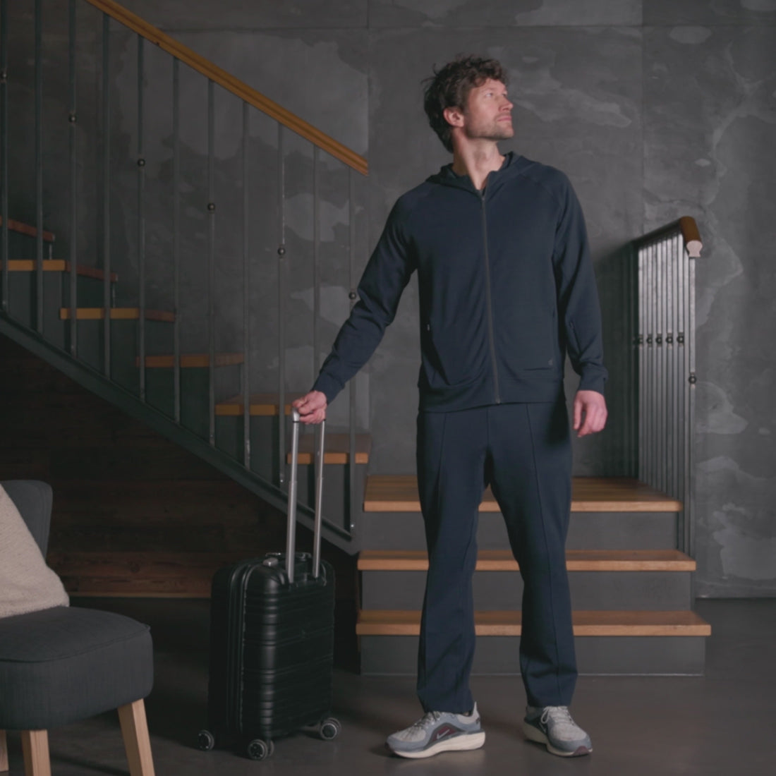 Mann iført mørk navy Travel Pants og hoodie fra Pysjkompaniet i premium travel wear-design for komfort og reise.