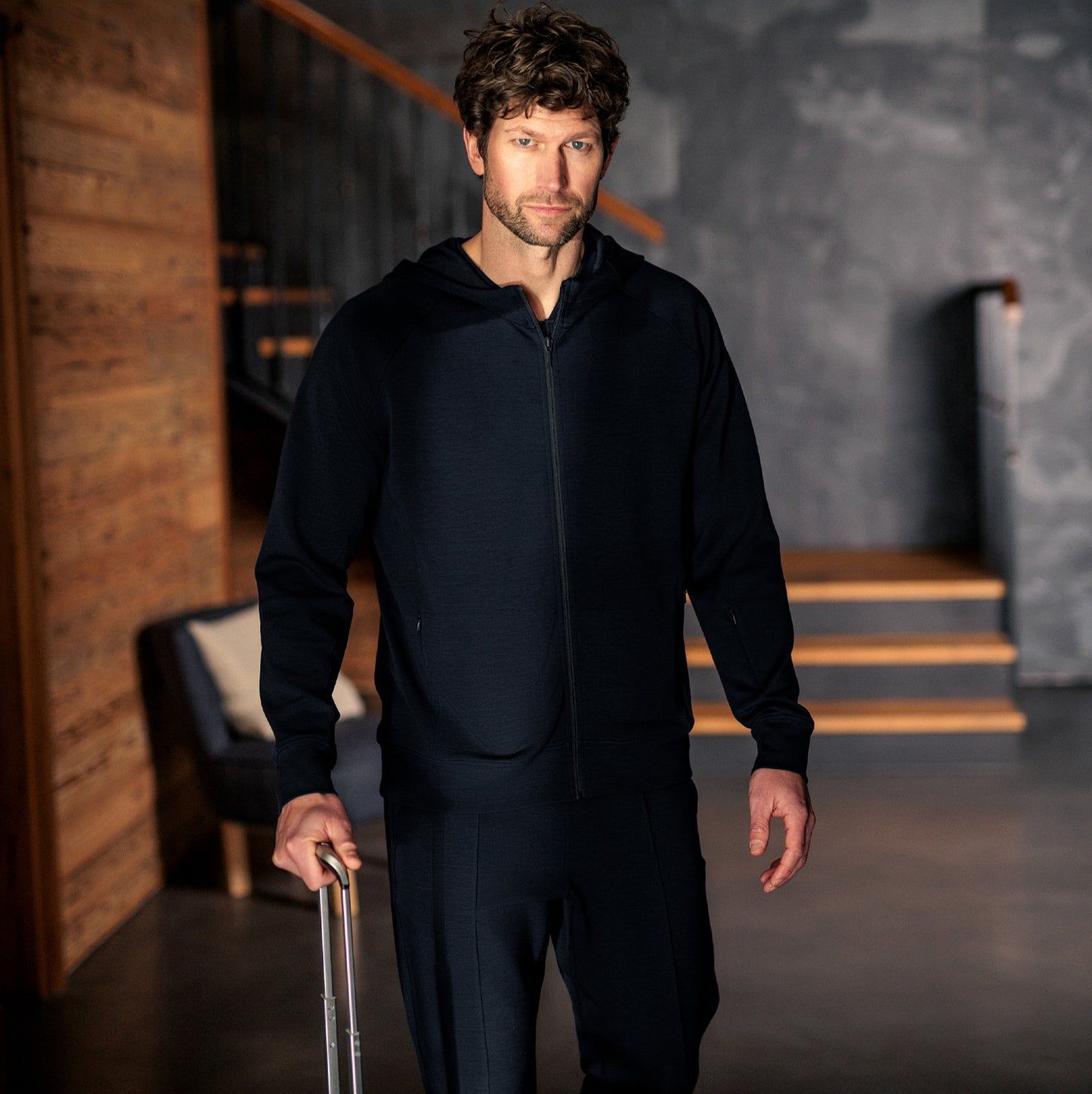 Mann iført mørk navy Travel Hoodie fra Pysjkompaniet i minimalistisk premium travel wear-design.