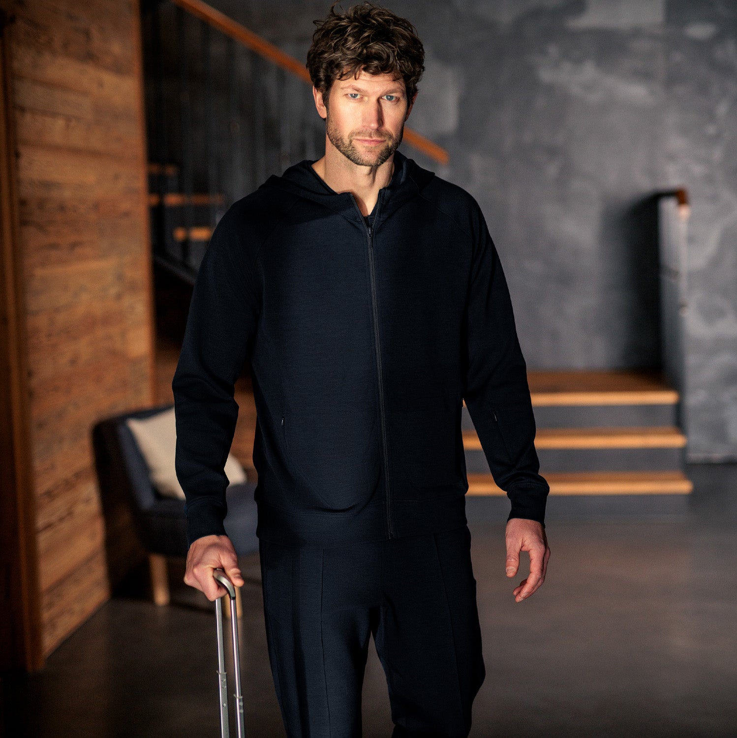 Mann iført mørk navy Travel Hoodie fra Pysjkompaniet i minimalistisk premium travel wear-design.