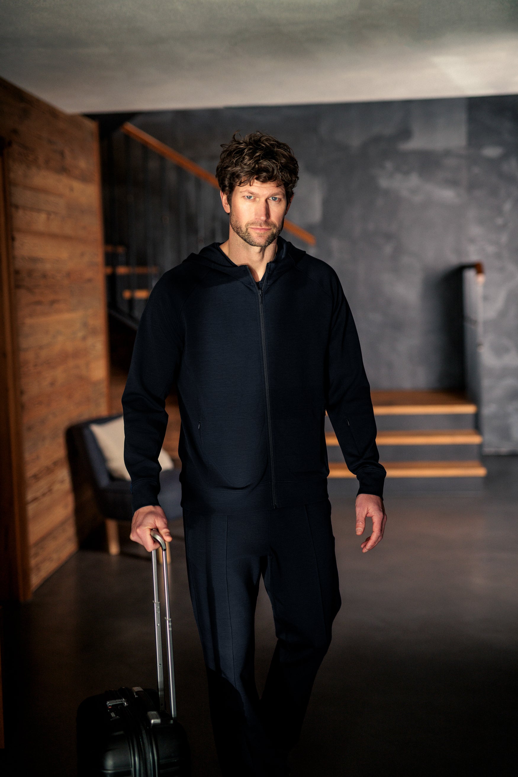 Mann iført mørk navy Travel Hoodie fra Pysjkompaniet i minimalistisk premium travel wear-design.
