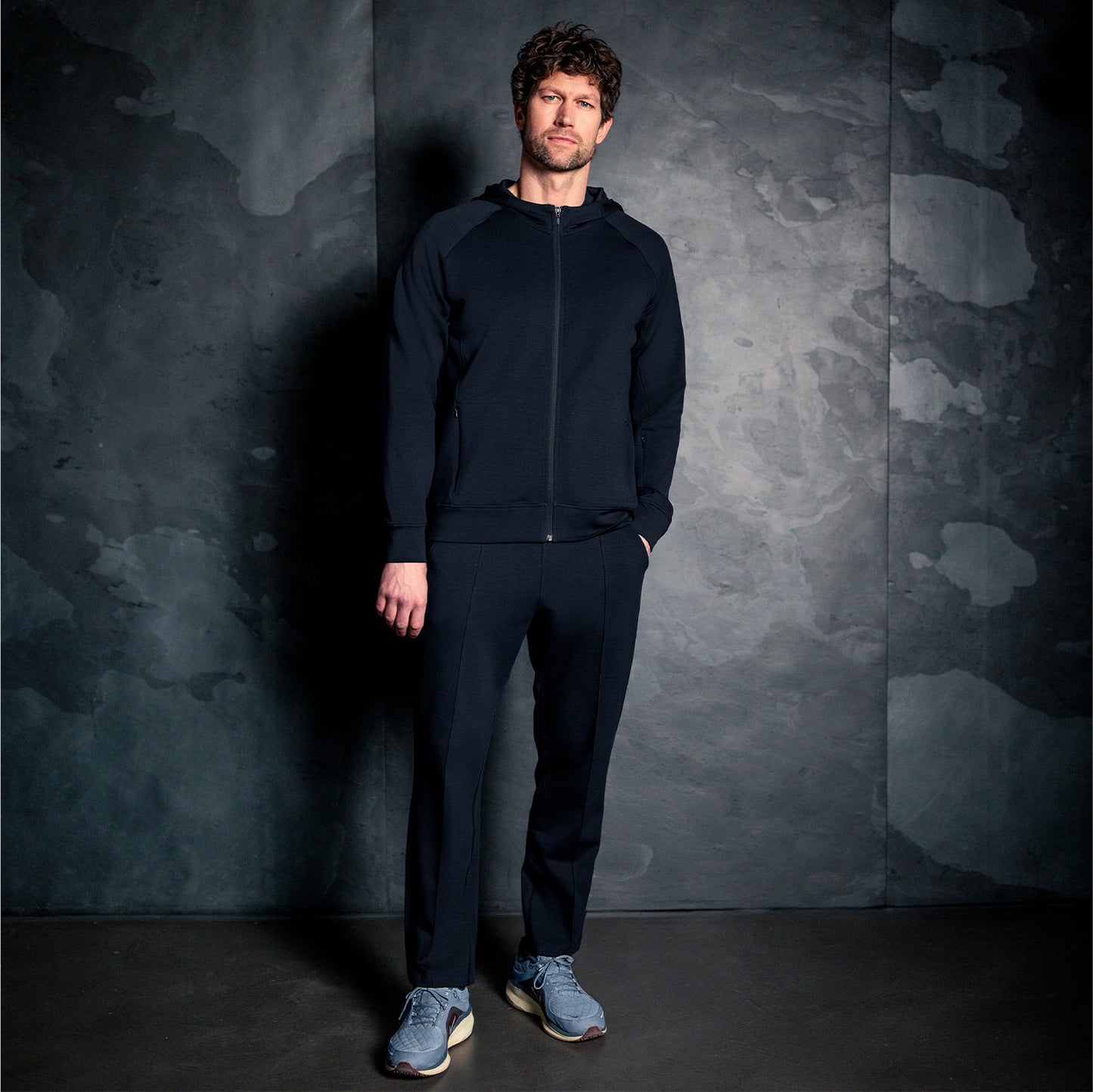 Mann iført mørk navy Travel Hoodie fra Pysjkompaniet i minimalistisk premium travel wear-design.