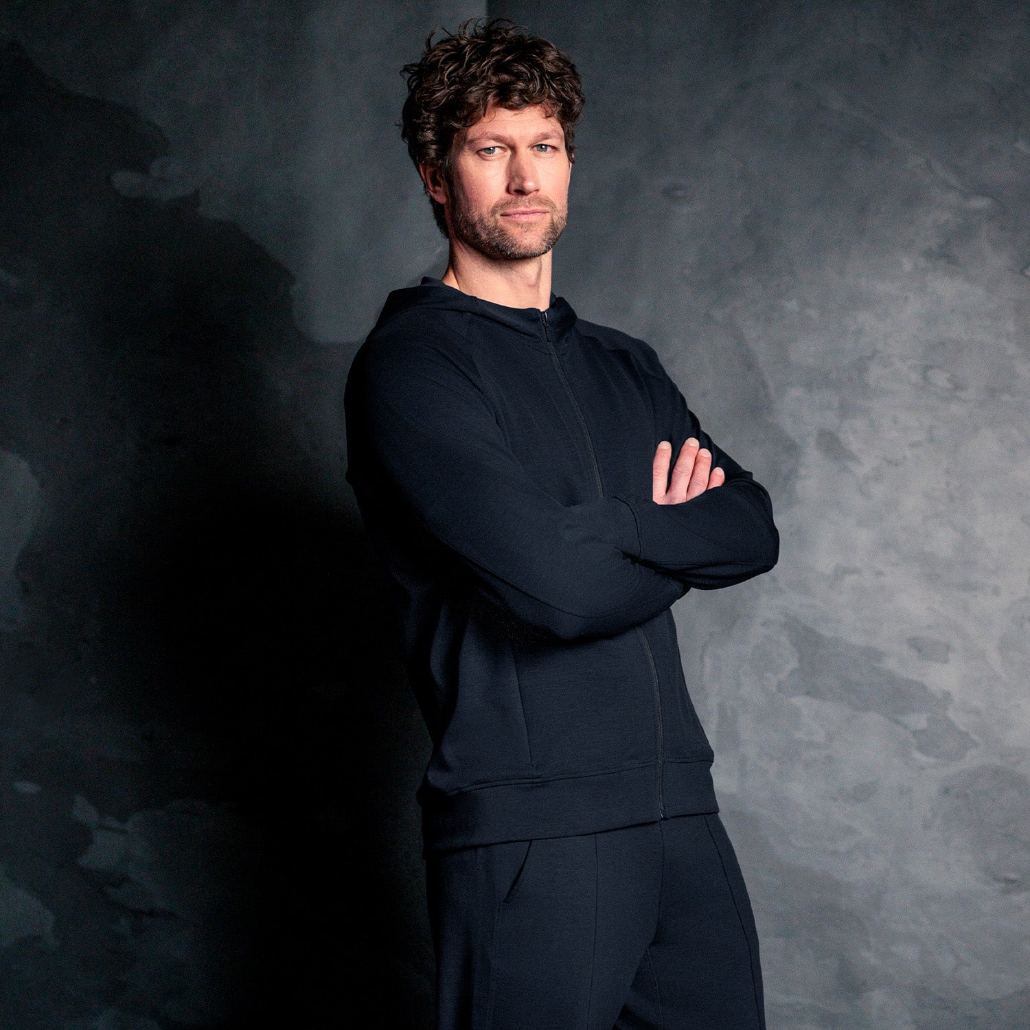 Mann iført mørk navy Travel Hoodie fra Pysjkompaniet i minimalistisk premium travel wear-design.
